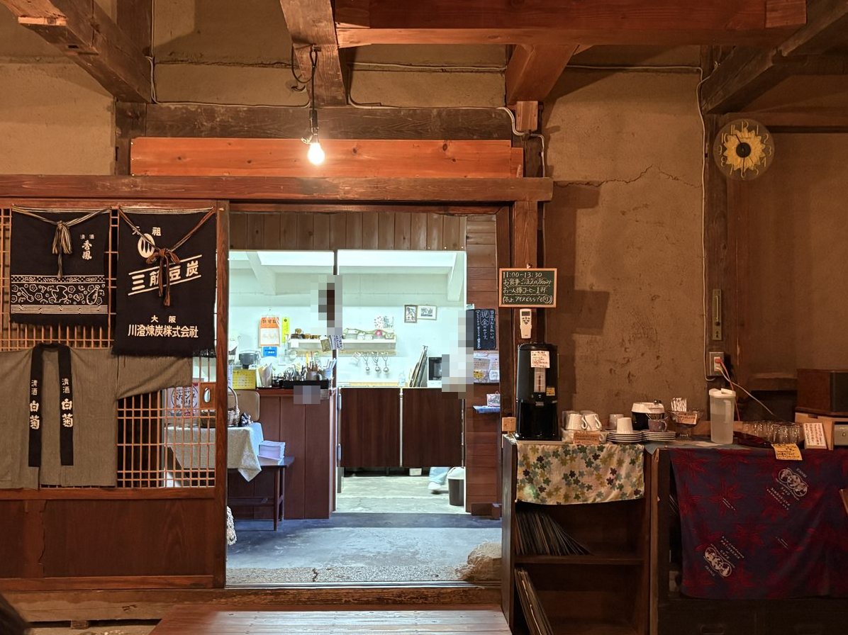 清酒や煉炭の名前が入った古い布が飾られた厨房の入口