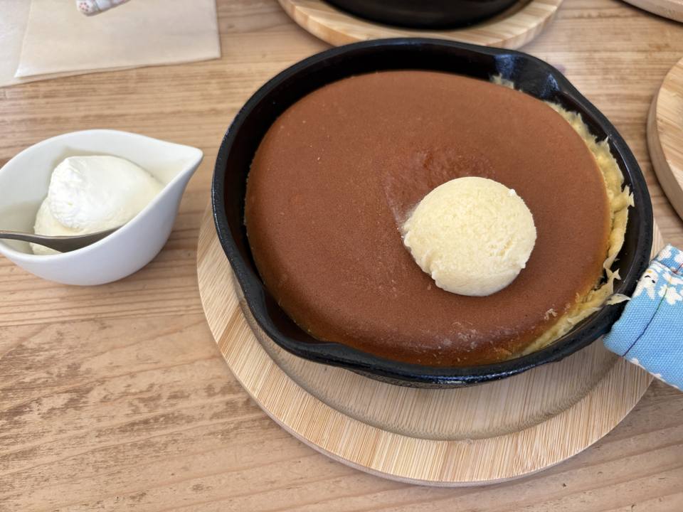 スノーハニーパンケーキ。スキレットにのったパンケーキの上にハニーバターがひとつ