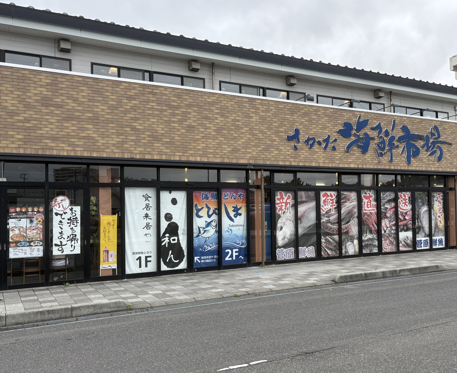 さかた海鮮市場の外観。1階に菅原鮮魚と喰居来居や 和ん、2階へ上がる海鮮どんや とびしまの案内が並ぶ