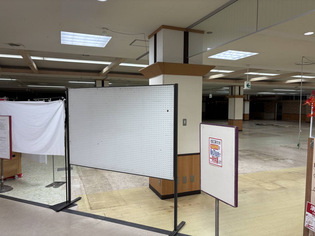 食品売場の入口に置かれた仕切りと休業を知らせる立て看板